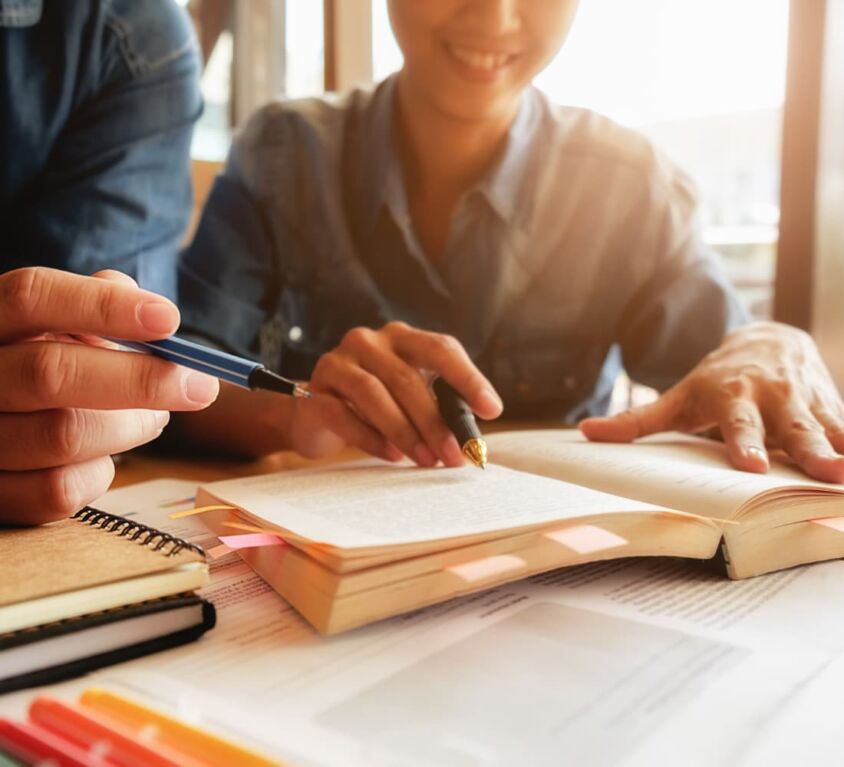 bildungskonzept-studentisches-studium-und-brainstorming-campus-konzept-nahaufnahme-von-studenten-diskutieren-ihr-thema-auf-buecher-oder-lehrbuecher-selektiver-fokus